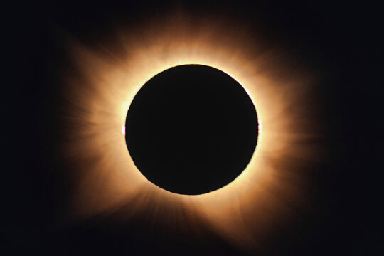 View of a total solar eclipse with the sun's corona glowing brightly around the dark lunar silhouette in the sky over Bellmunt del Priorat, Catalonia, Spain.