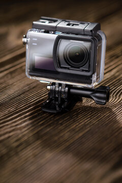 Action camera in waterproof case on wooden table. Copy space