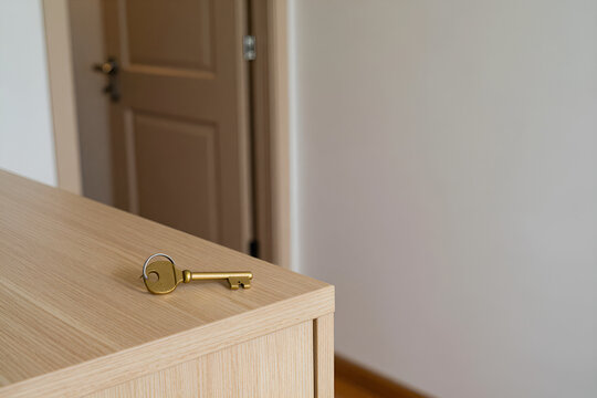 Brass house key on a ring resting on a console table in an apartment entrance