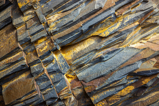 View of layered sedimentary rock formations with distinct yellow and grey mineral deposits in Tuzbair, Mangystau District, Mangystau Region, Kazakhstan.