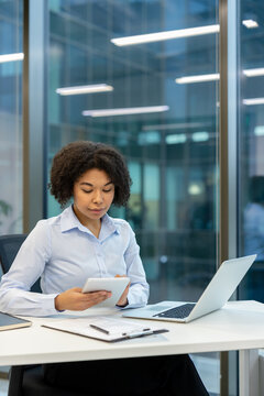 Remote work and digital transformation, professional woman using a tablet and laptop in a modern office for business productivity and corporate communication