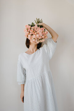 Woman in white and blue holding fresh cut roses
