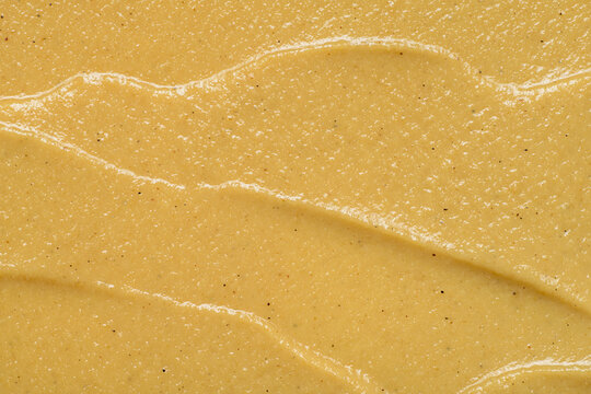 Mustard sauce spread creating a textured yellow background
