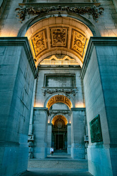 View of the monumental Cinquantenaire Arch with its intricate stone carvings and illuminated vaulted ceilings in Brussels, Brussels, Belgium.