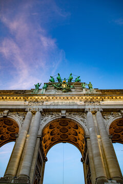 View of the Cinquantenaire Arch with its bronze quadriga sculpture and detailed stone arches against a clear blue sky in Brussels, Brussels, Belgium.