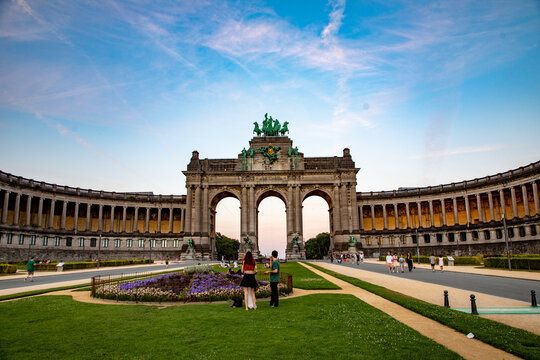 View of the Cinquantenaire Arch with its grand stone architecture and surrounding park grounds under a clear blue sky in Brussels, Brussels, Belgium.