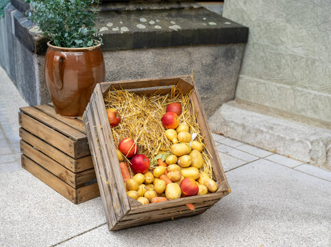 Wooden Crate with Straw and Fresh Vegetables at Autumn Market
