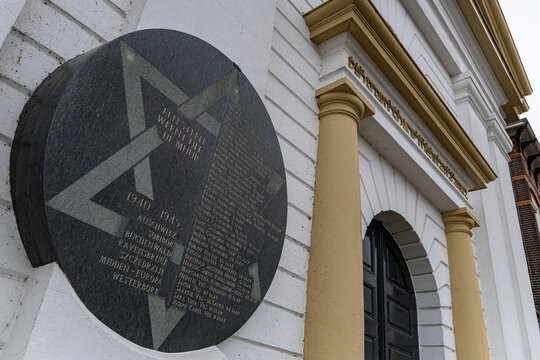 View of the Joods Monument Kampen, a memorial plaque featuring a Star of David and names of victims, mounted on a white building wall in Kampen, Overijssel, Netherlands.