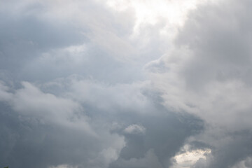 Fototapeta premium A dramatic view of thick grey clouds covering the sky with bright sunlight breaking through the upper right corner. The stormy overcast atmosphere creates a moody and dynamic natural background.