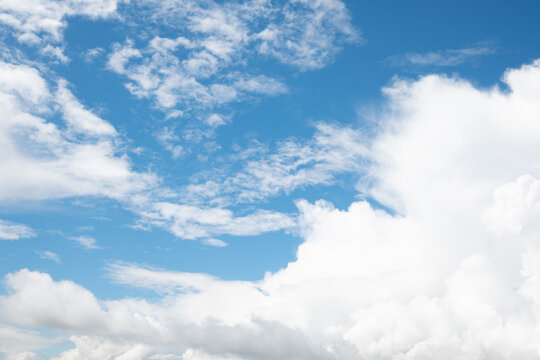 A scenic blue sky featuring soft wispy cirrus clouds and fluffy white cumulus formations. The bright natural light creates an uplifting and relaxing outdoor atmosphere.