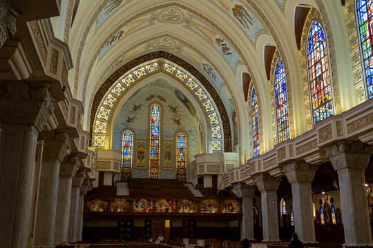 View of the ornate interior of a Coptic Orthodox cathedral featuring high vaulted ceilings, intricate stained glass windows, and stone columns in Cairo, Cairo Governorate, Egypt.