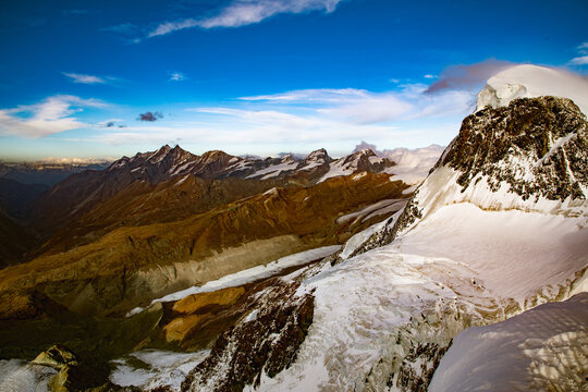 View of the snow-capped Matterhorn peak and surrounding alpine glaciers under a clear blue sky in Zermatt, Valais, Switzerland.