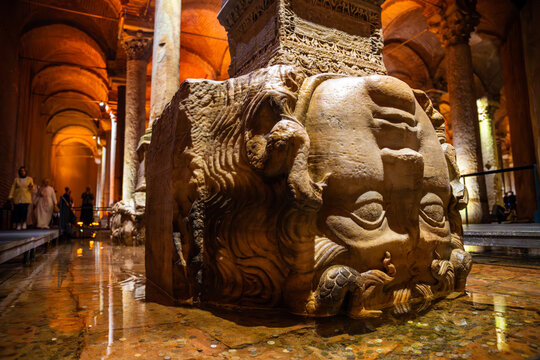  Medusa head sculpture at Basilica Cistern in Istanbul, Turkey, surrounded by water and illuminated by warm lighting