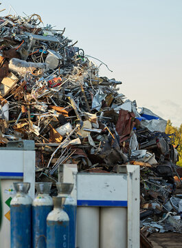 Scrap metal recycling waste industrial salvage yard with mixed materials, steel, aluminum, cables and discarded equipment awaiting sorting, processing and material recovery