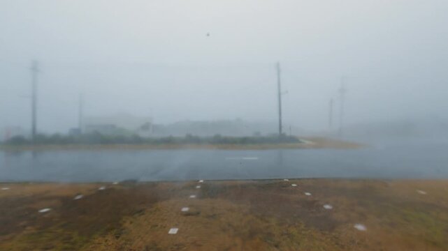 Powerful Hurricane Winds And Torrential Rain Sweep Across Road At Landfall