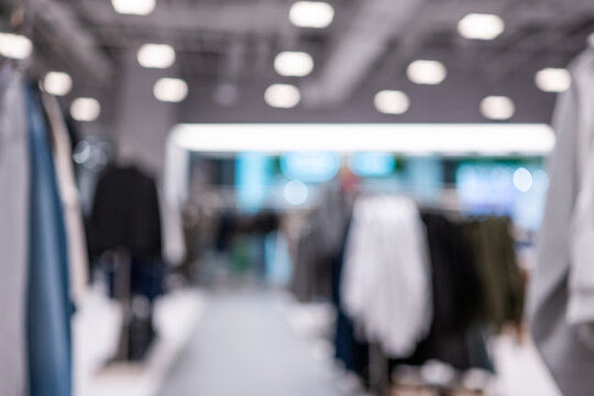 Blurred clothing racks inside a bright modern retail store