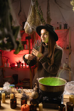 A realistic witch brewing a potion in a cauldron. She selects the herbs needed for her spell. Everyday life intertwined with traditional witchcraft, magic, and a mystical atmosphere.