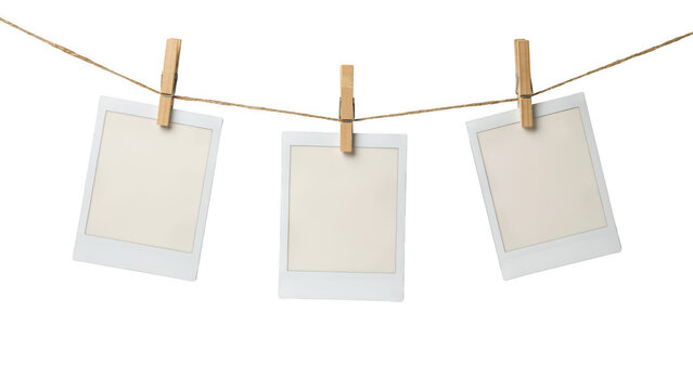 Three blank polaroid photos hanging on a clothesline with clothespins isolated on transparent background