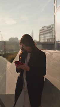 Happy woman using mobile phone in vibrant urban setting