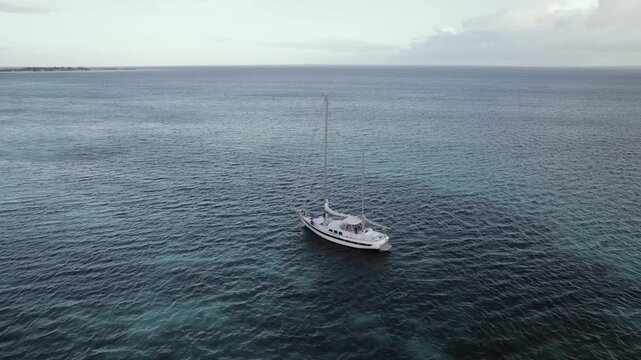 Aerial orbit view of a sailboat near the coast of Gran Roque, Los Roques, Venezuela. Video 4 k Dlog
