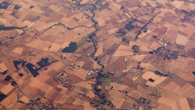 High Aerial View over French Countryside Landscape with Field Patterns and Dry Ground After Drought and Heatwaves.