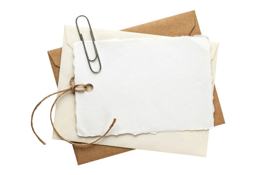Blank white paper tag with twine, metal clip, and stacked envelopes isolated on a transparent background