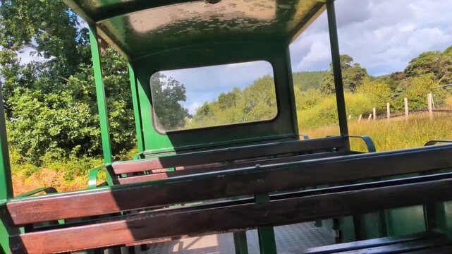 Backward Facing POV Travelling Along Small Train Through Fields and Forests.