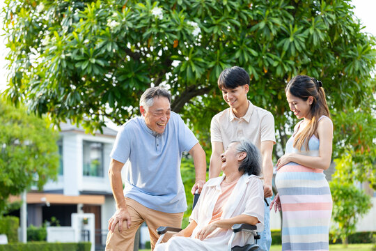 Heavily pregnant asian woman in her third trimester is enjoying her happy time outdoor with her supporting family and senior parent in relaxation for maternity, motherhood, in law and extended family
