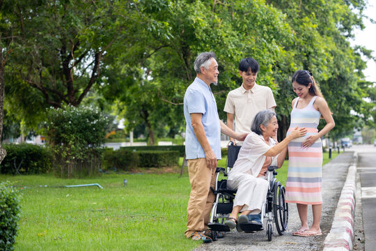 Heavily pregnant asian woman in her third trimester is enjoying her happy time outdoor with her supporting family and senior parent in relaxation for maternity, motherhood, in law and extended family