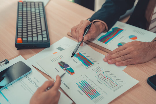 Business people working together discussing financial chart statistics and analysis strategy with laptop computer at office table.