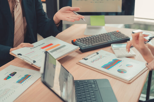 Business people working together discussing financial chart statistics and analysis strategy with laptop computer at office table.