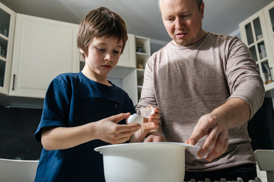Father and son baking together in kitchen