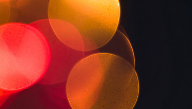 Abstract defocused red orange yellow light orbs on solid black background, warm colorful bokeh glow texture, soft blur overlay effect Generative AI
