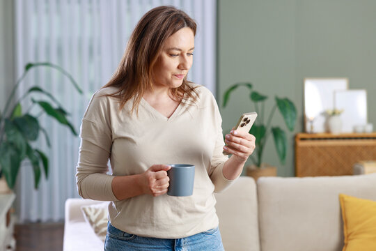 Woman drinking coffee while using smartphone
