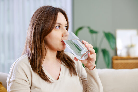 Woman drinking water at home