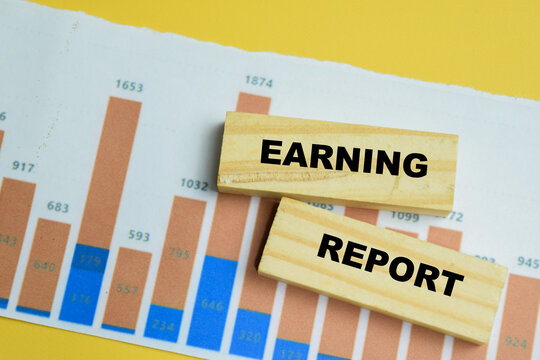 Concept of earning report text on wooden blocks.
