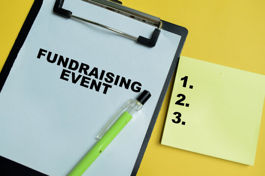 Concept of fundraising event write on clipboard isolated on table. For purpose is to raise money for a cause