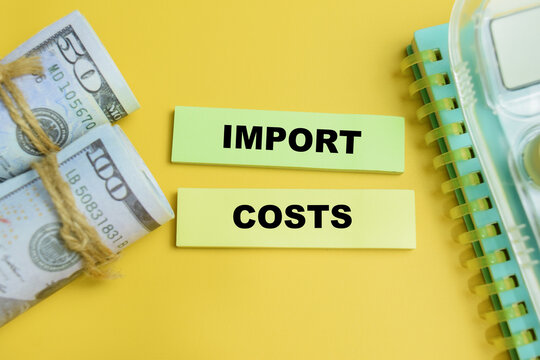 Concept of import costs write on sticky notes isolated on table. For international trade expense and tariff
