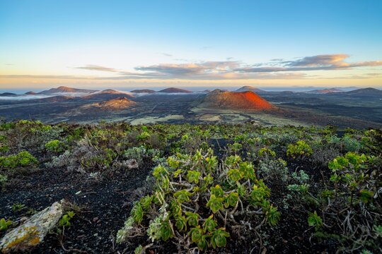 Picturesque volcanic landscape with volcanic craters and lava fields at sunrise, Caldera Colorada volcano and Volc&aacute;n de Las Nueces, Parque Natural de Los Volcanes, Lanzarote, Canary Islands, Spain