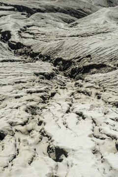 Hostile volcanic landscape, gaps and cracks, dry ground on volcano crater, Mount Bromo, Bromo Tengger Semeru National Park, Java, Indonesia