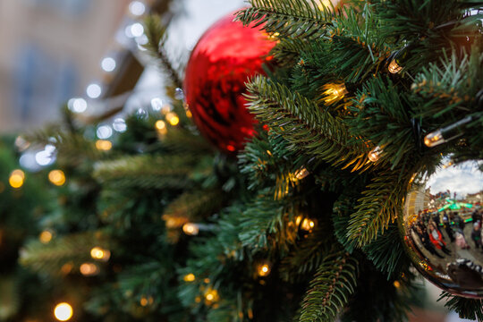 Close up of Christmas tree branches with festive baubles and lights
