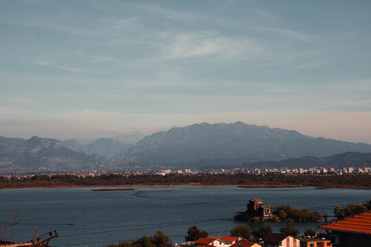 A panoramic view of a calm body of water with distant mountains under a cloudy sky