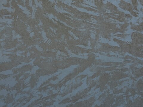 Abstract textured wall surface background showcasing rough plaster brush strokes creating a rustic decorative pattern, a common architectural detail