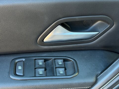Car door panel featuring a metallic handle and electric window control buttons, highlighting automotive interior design and passenger convenience in modern vehicles