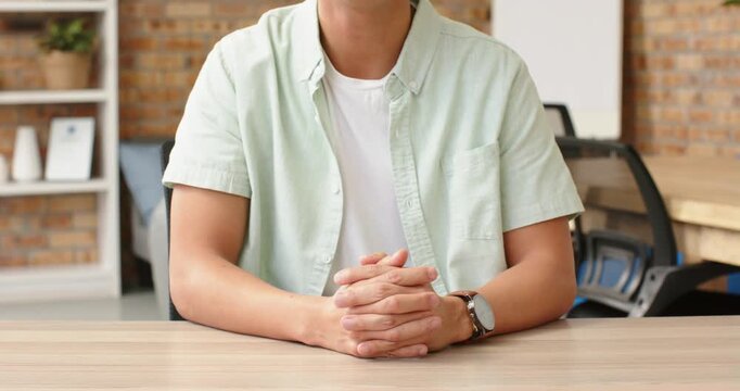 Close up of people talking to the camera, sitting at desk, man in casual shirt folding hands in offi