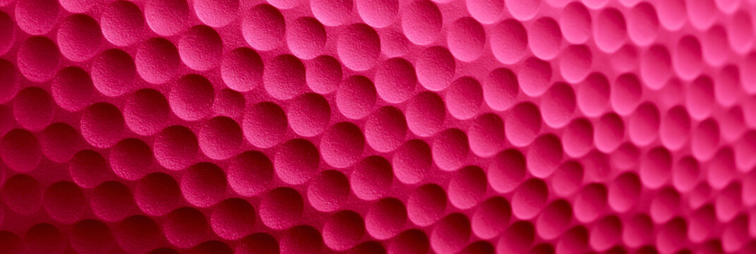 Rosa pinke Oberfl&auml;che mit gleichm&auml;&szlig;igem Muster aus Sechsecken als abstrakter Texturhintergrund im Querformat