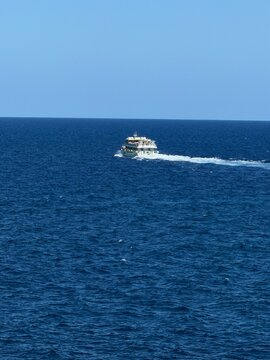 Ferry boat slicing deep blue mediterranean waters near manacor, balearic islands, leaving a white wake under a clear sky  travel, freedom and coastal exploration