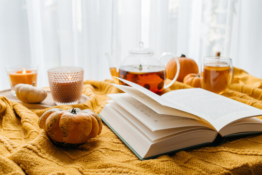Cozy autumn reading with hot tea and pumpkins