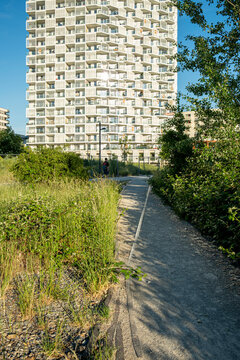 Path through green public space leading to a modern residential tower in Nordbahnviertel Vienna Austria showing contemporary urban development