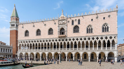 Fototapeta premium The magnificent Venetian Gothic Doge's Palace facade featuring delicate pink marble open arcades and intricate tracery under bright daylight. Venice, Italy.